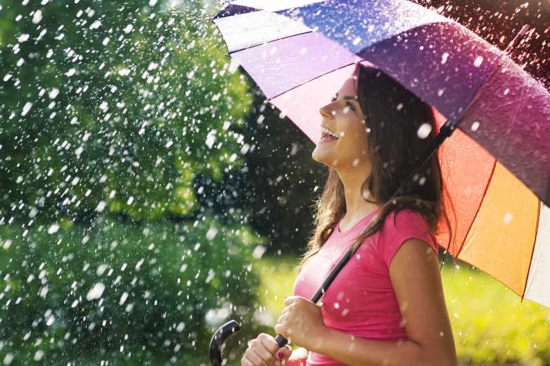 下雨天时撑着伞站在雨中的女人