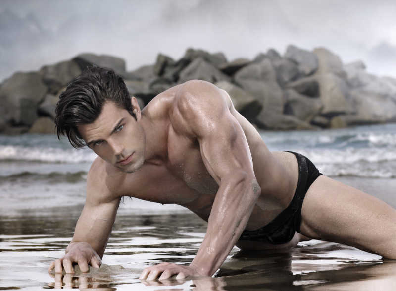 在异国情调海滩上美丽迷人的男模