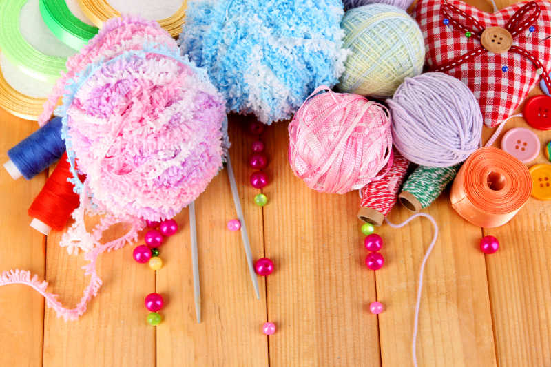 木色背景下的针织用品毛线团针织棒等