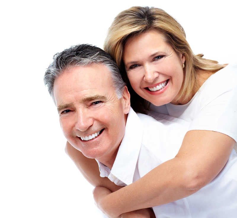 白色背景下穿着白色衣服微笑的中年夫妇