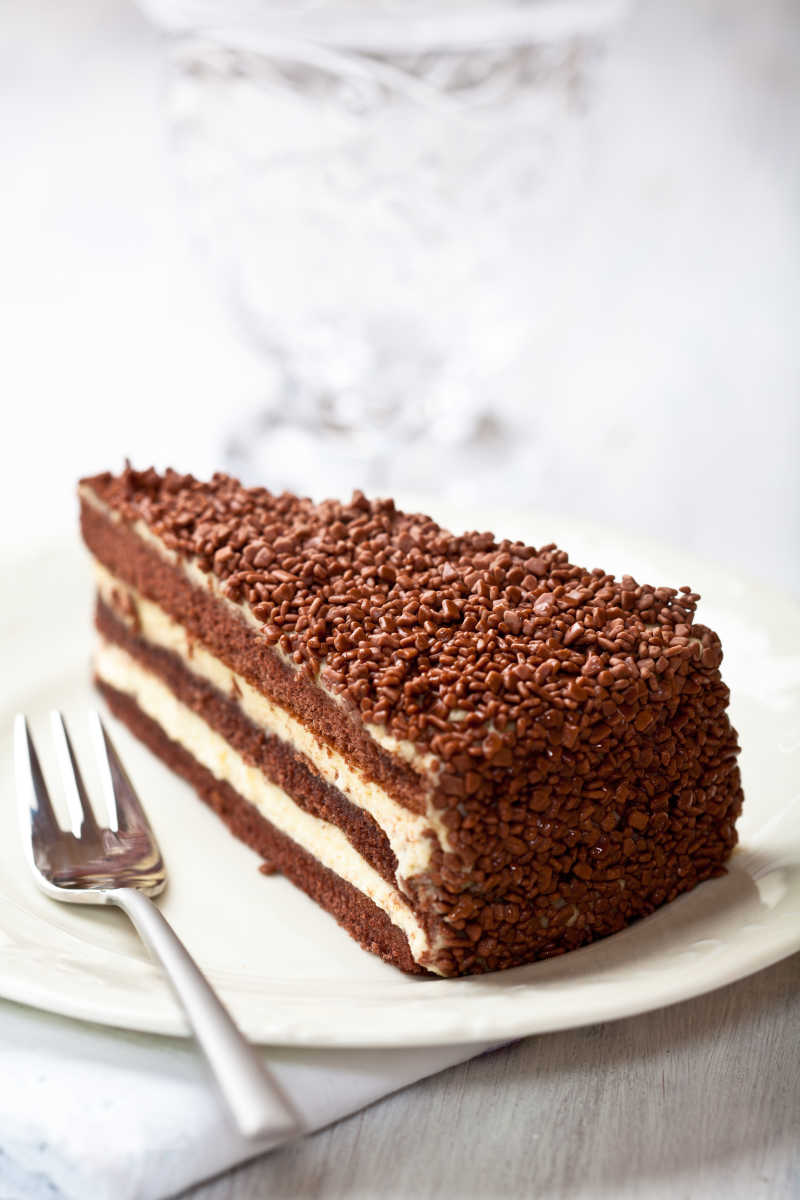 白色瓷盘里的金属叉和巧克力奶油蛋糕