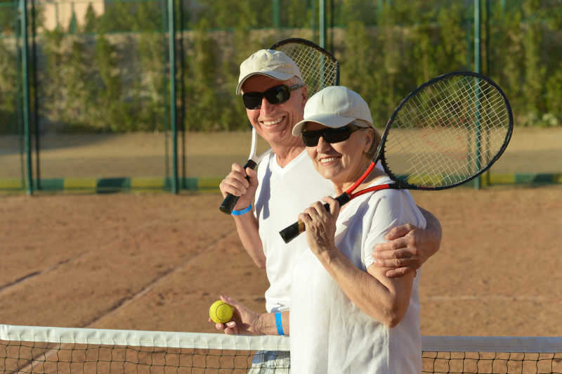 快乐可爱的老夫妇在户外打网球