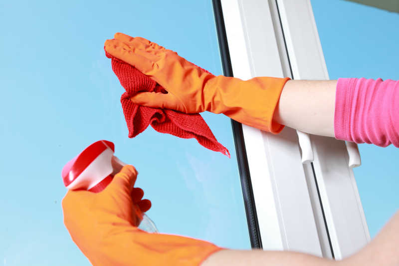 用抹布和喷雾清洁剂擦窗