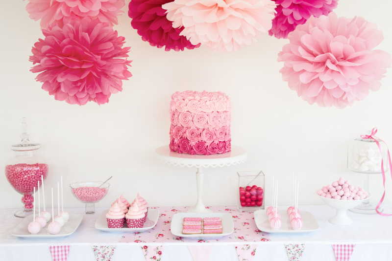 粉红背景中甜点桌上的糖果和蛋糕
