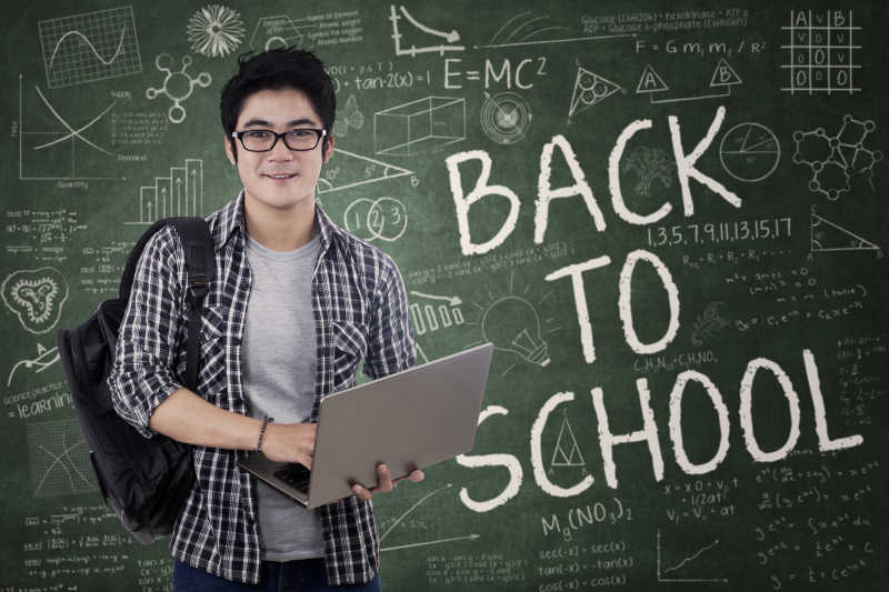 一个学生在课堂上手持笔记本电脑