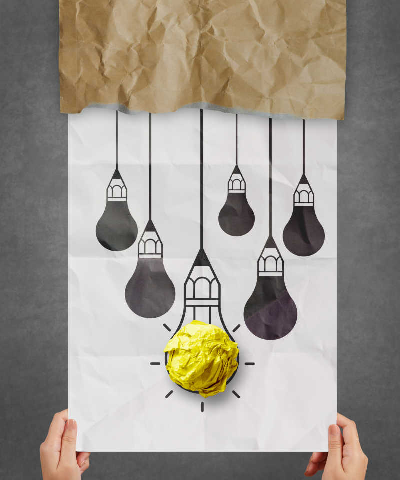 揉皱的纸张和纸上手绘灯泡作为创意想法概念