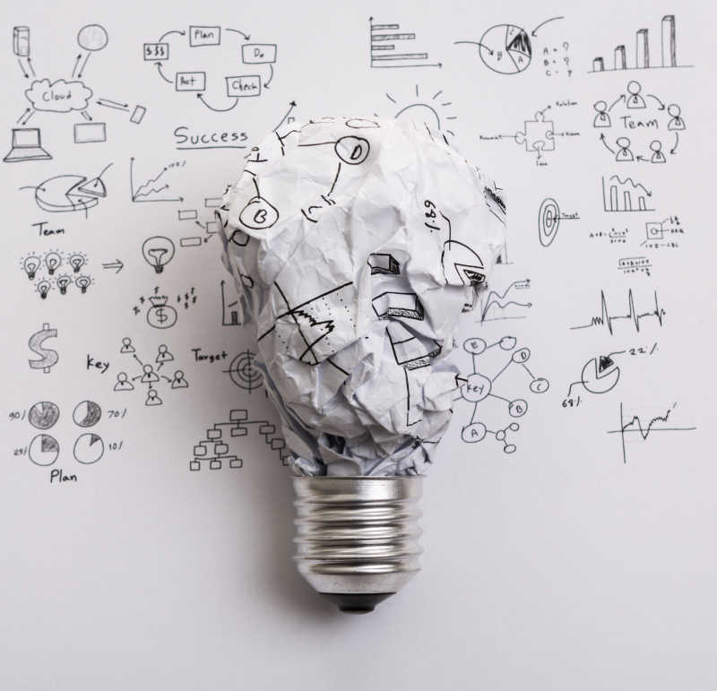 画着图纸揉皱的纸作为灯泡创意想法概念