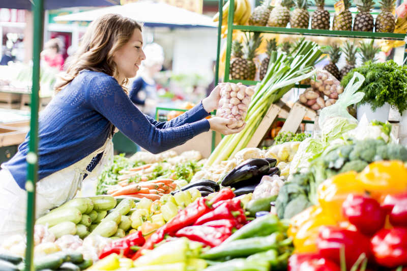 市场上购买蔬菜的家庭主妇