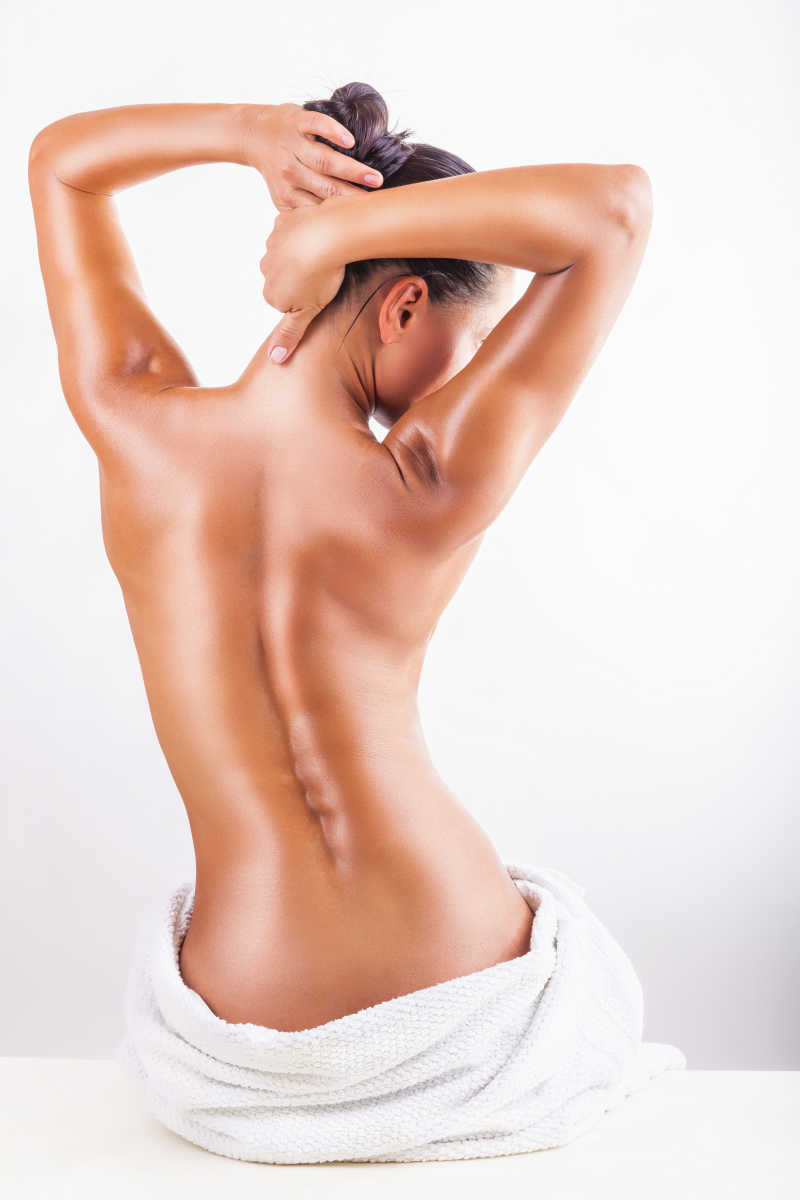 白色背景下用毛巾裹着下身的性感美女背部摄影