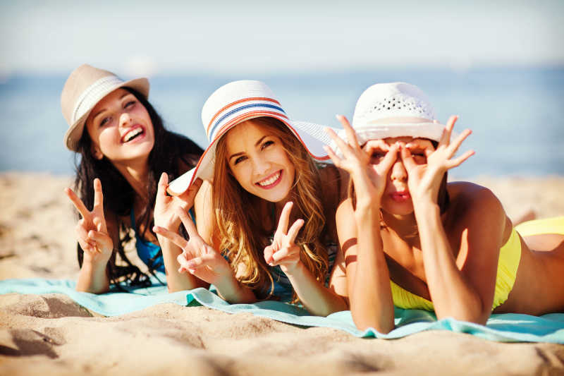 三个女孩在海滩上晒日光浴