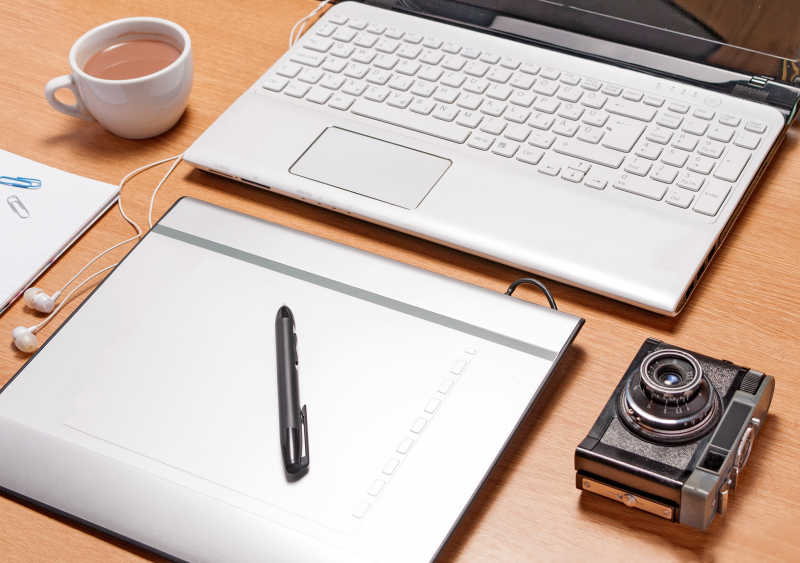 办公桌上的笔记本电脑和照相机