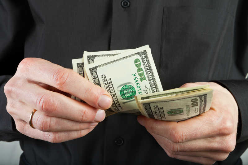手里拿着美元的商人