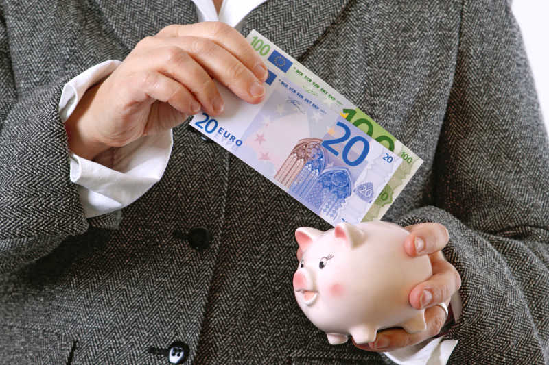 把纸币塞进存钱罐,