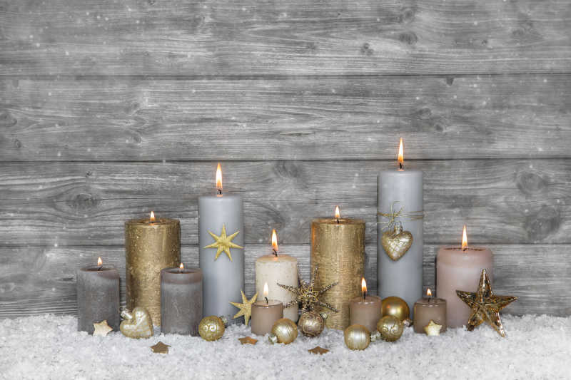 木墙边点燃的蜡烛和圣诞节装饰品