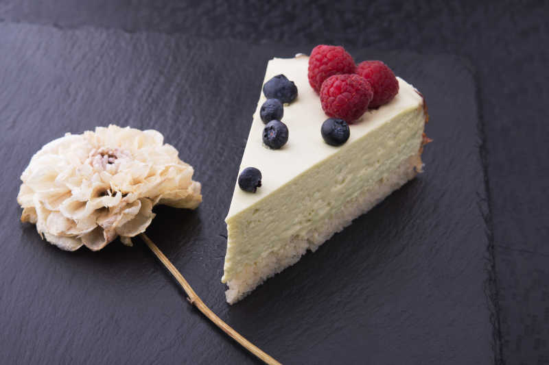 美味的浆果装饰的蛋糕和花