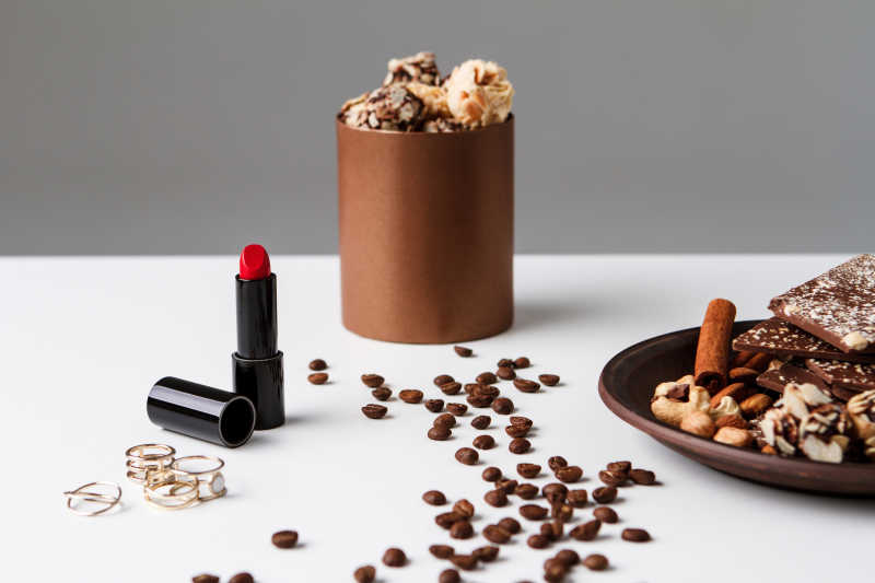 白色背景下的口红和咖啡豆