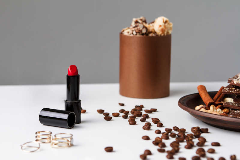 白色背景上的咖啡豆和口红
