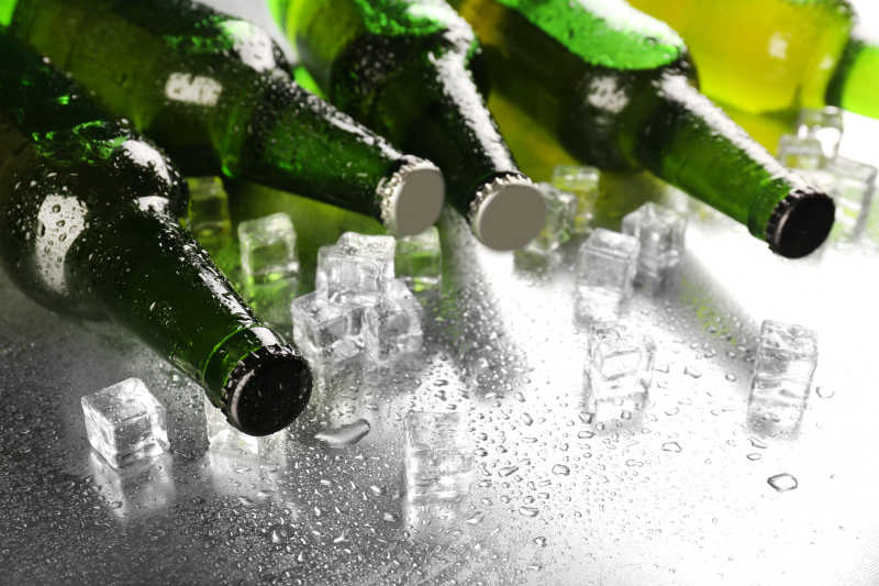 湿桌面冰块和玻璃瓶