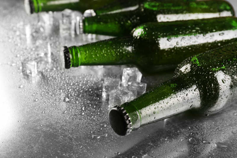 湿桌面上带水珠的啤酒瓶
