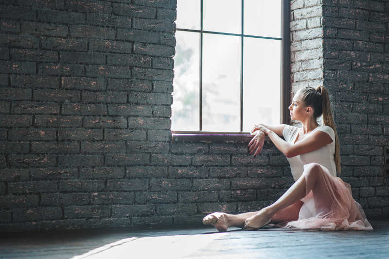 年轻舞者练习后坐在地板上放松