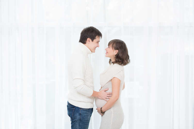 孕妇与丈夫在窗边拥抱