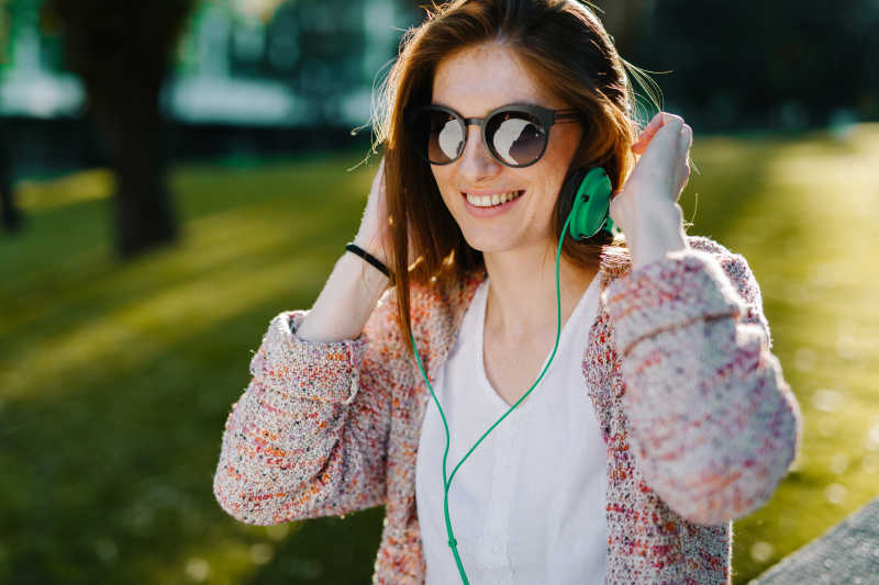 公园长凳上听歌的性感美女