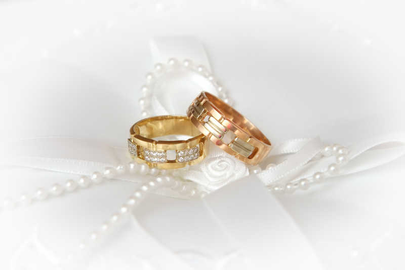 白丝绸上的珍珠和戒指