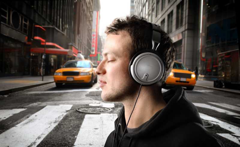 在城市街道上听音乐的年轻人