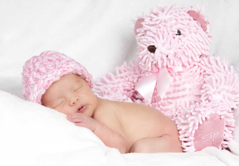 熟睡的婴儿和粉色泰迪熊