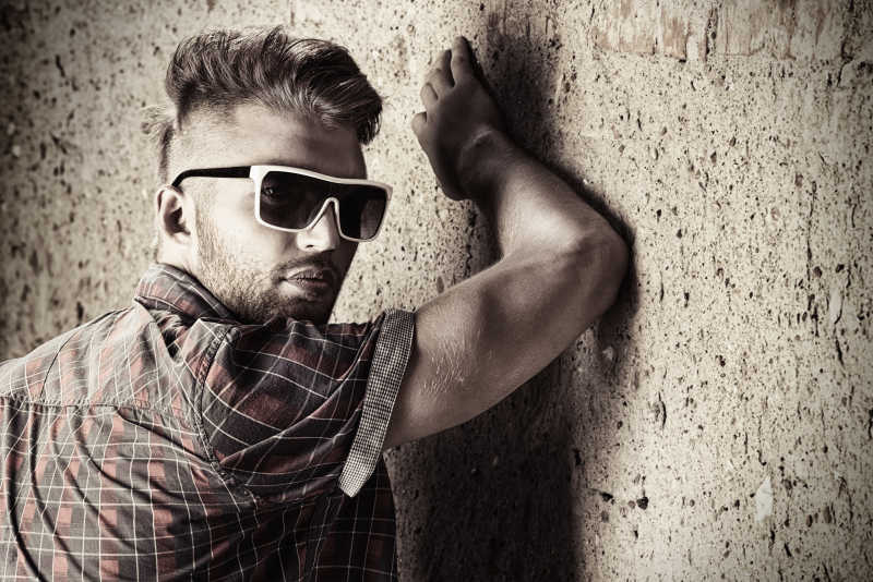 砖墙背景下的时尚帅气的年轻男子