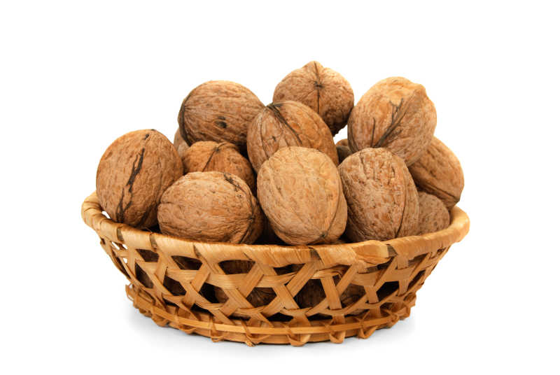 白色背景下的木篮里的核桃