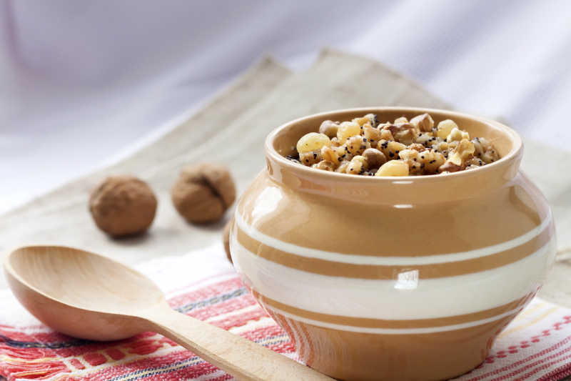 陶瓷罐里的谷物布丁和木铲核桃