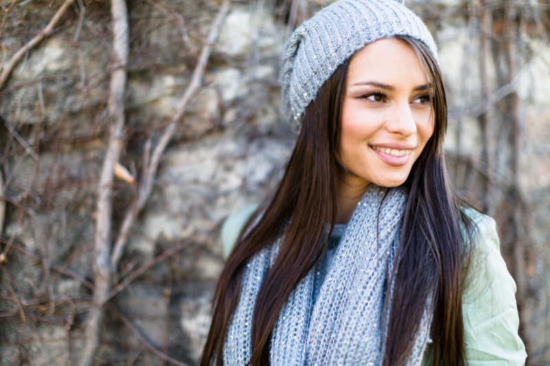 户外带着蓝色帽子和围巾的长发美女