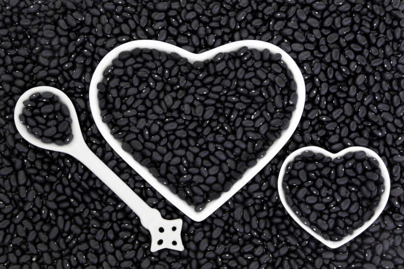 黑豆保健食品在瓷心菜和汤匙形成一个抽象的背景