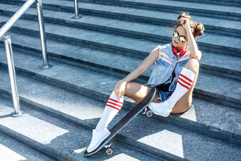 坐在阶梯上的滑板女孩