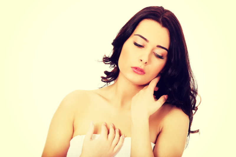 裹着白色毛巾的年轻美丽的女子