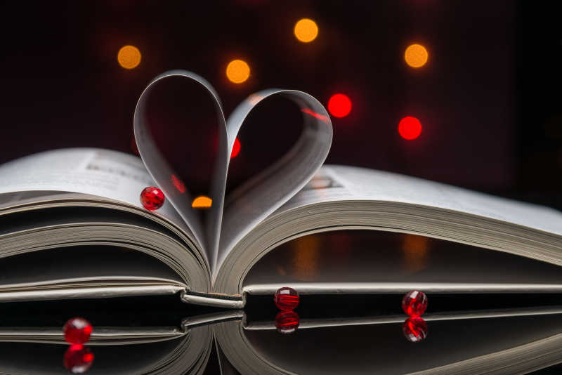 书页卷成的心形和红色的小球