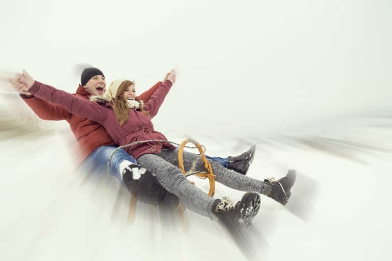 年轻的夫妻坐在雪橇上