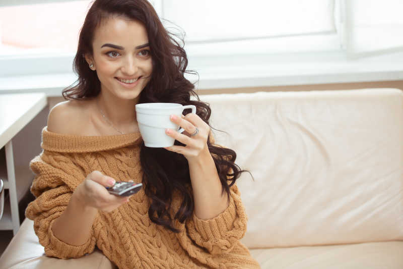 喝咖啡看电视的年轻美女