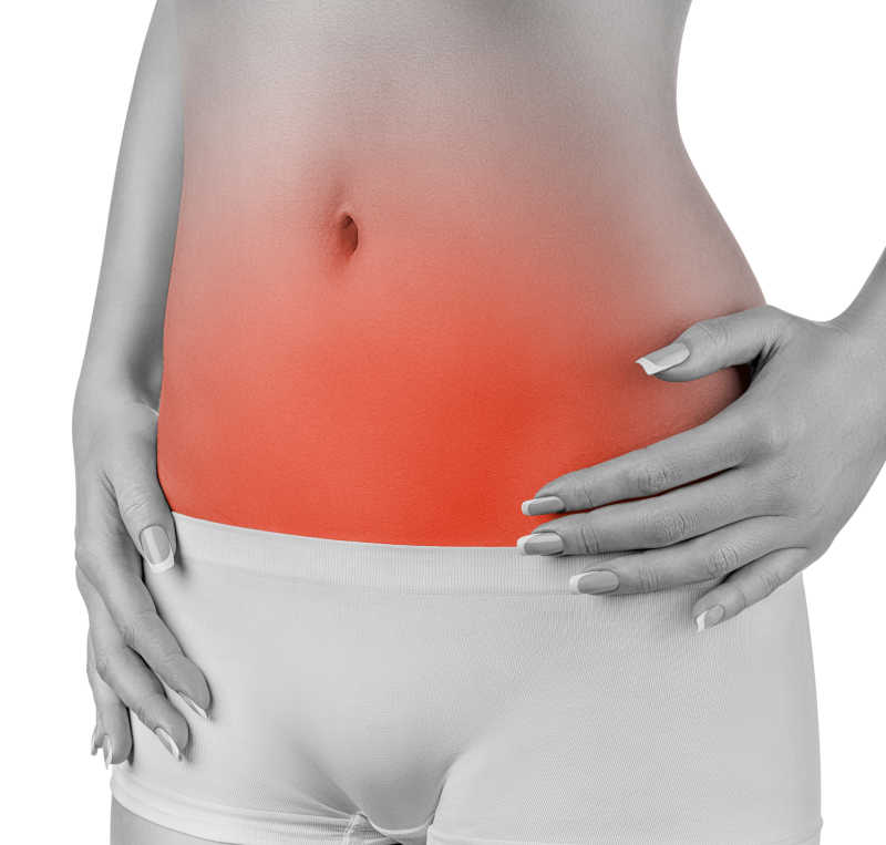 白色背景下腹痛的年轻女人