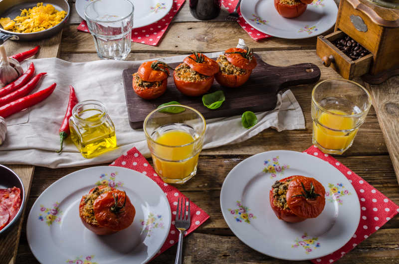 桌子上的香草烤番茄和橙汁