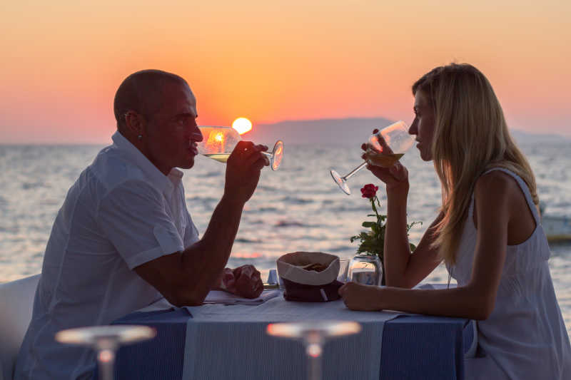 在海边餐厅喝酒对饮的约会情侣