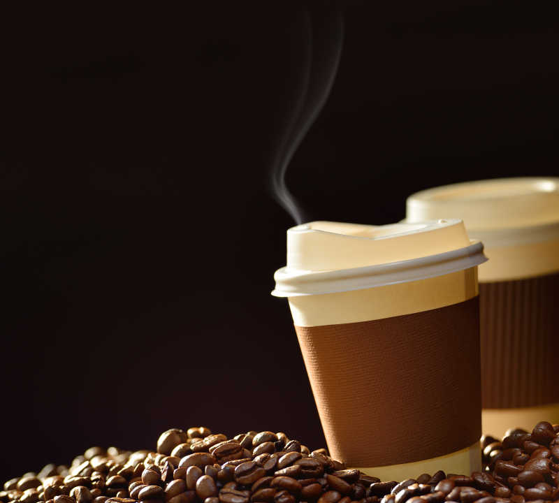 木桌上的杯装咖啡和咖啡豆