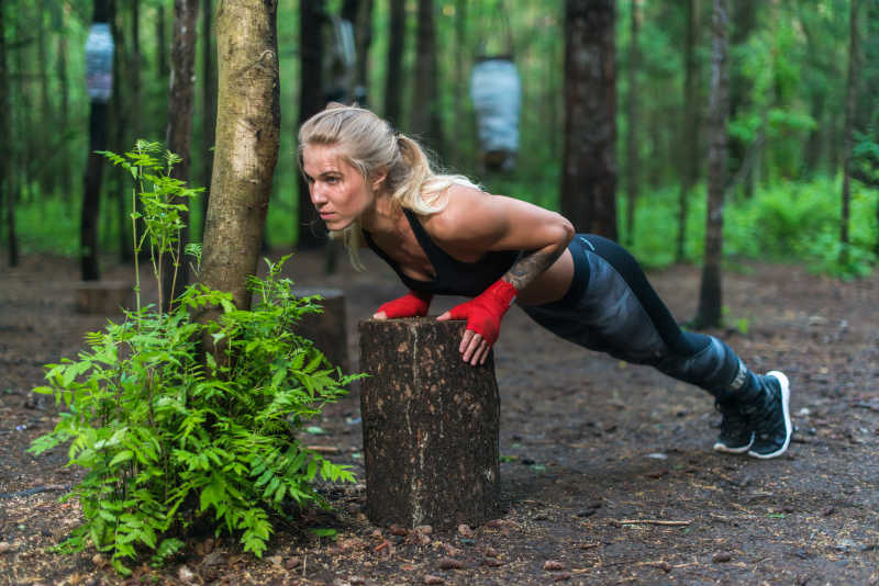 健壮的女人在公园街做俯卧撑