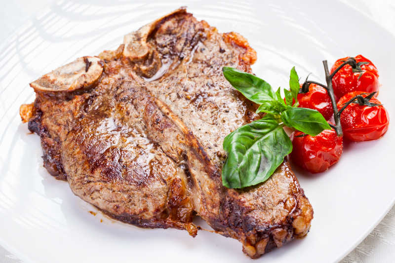 白色盘子中的烤T骨牛扒