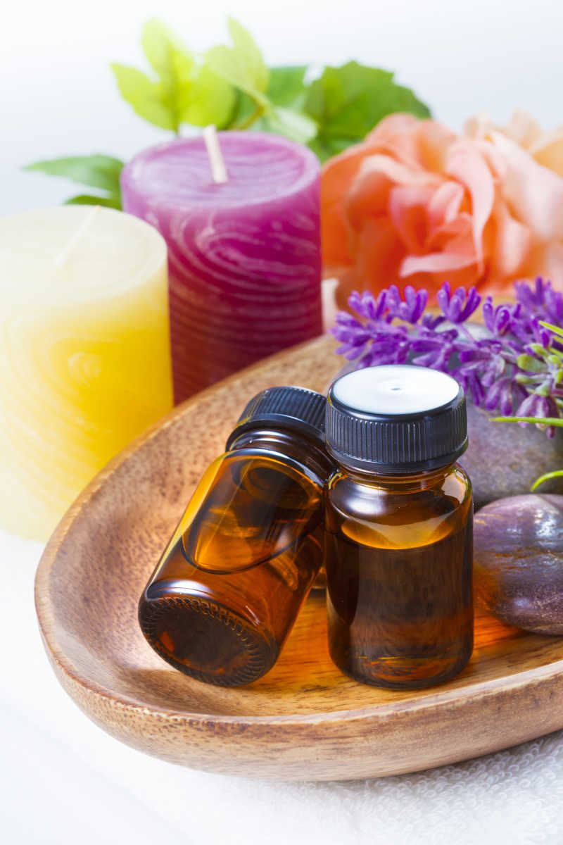 木盘里的精油和一边的香薰蜡烛