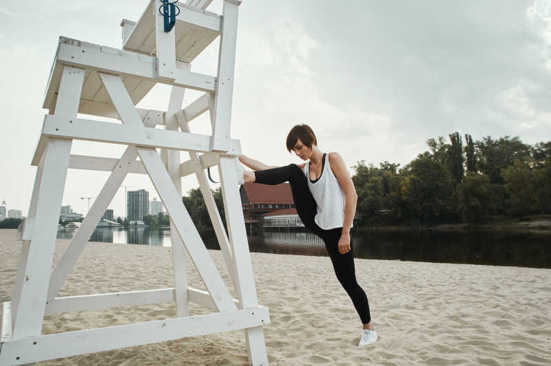 可爱的黑色运动装美女做伸展运动