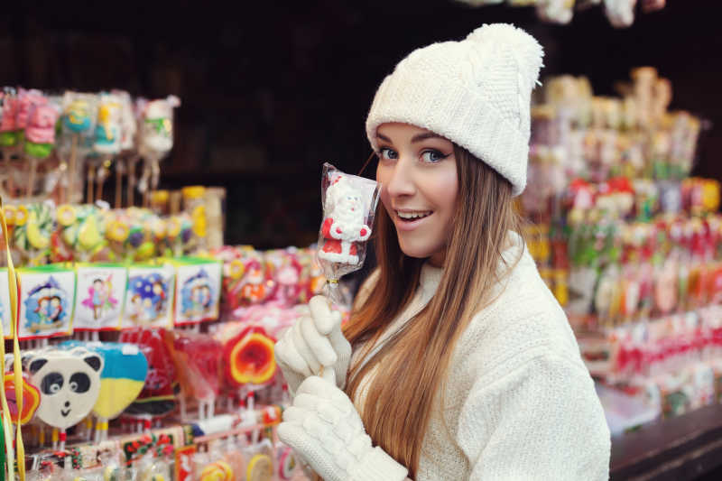 在集市上买糖果的美女