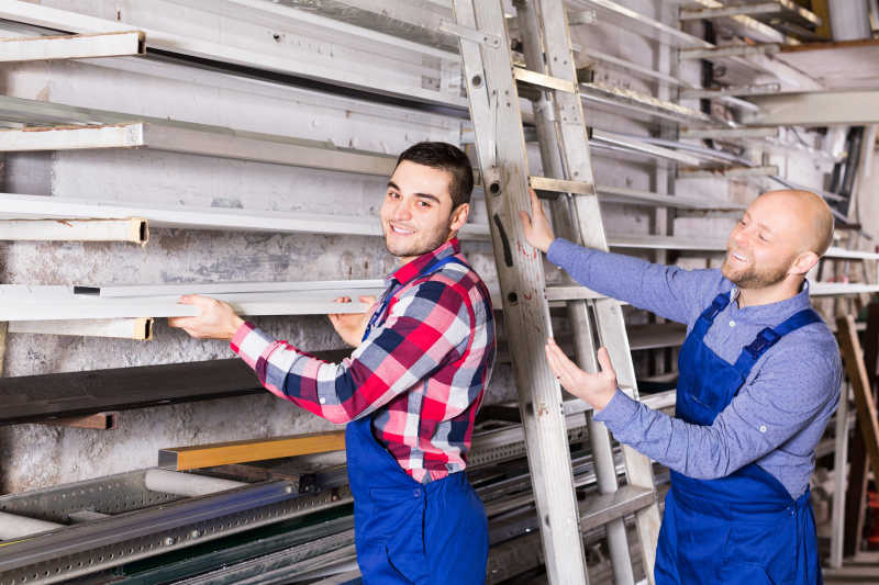 搬运窗框的两名工人