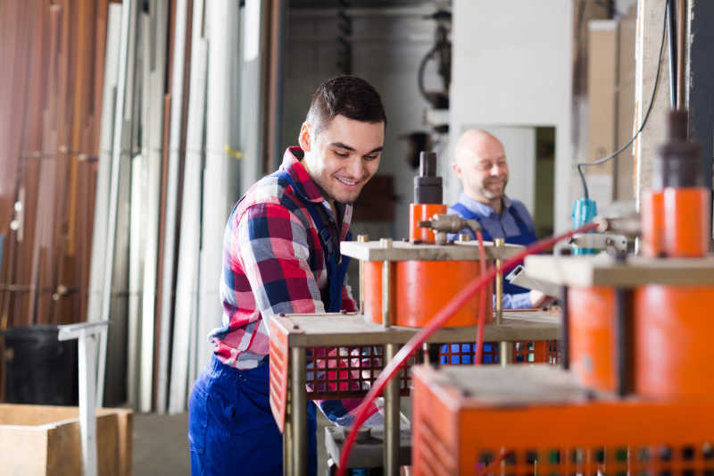 聚氯乙烯车间设备旁开心工作的员工